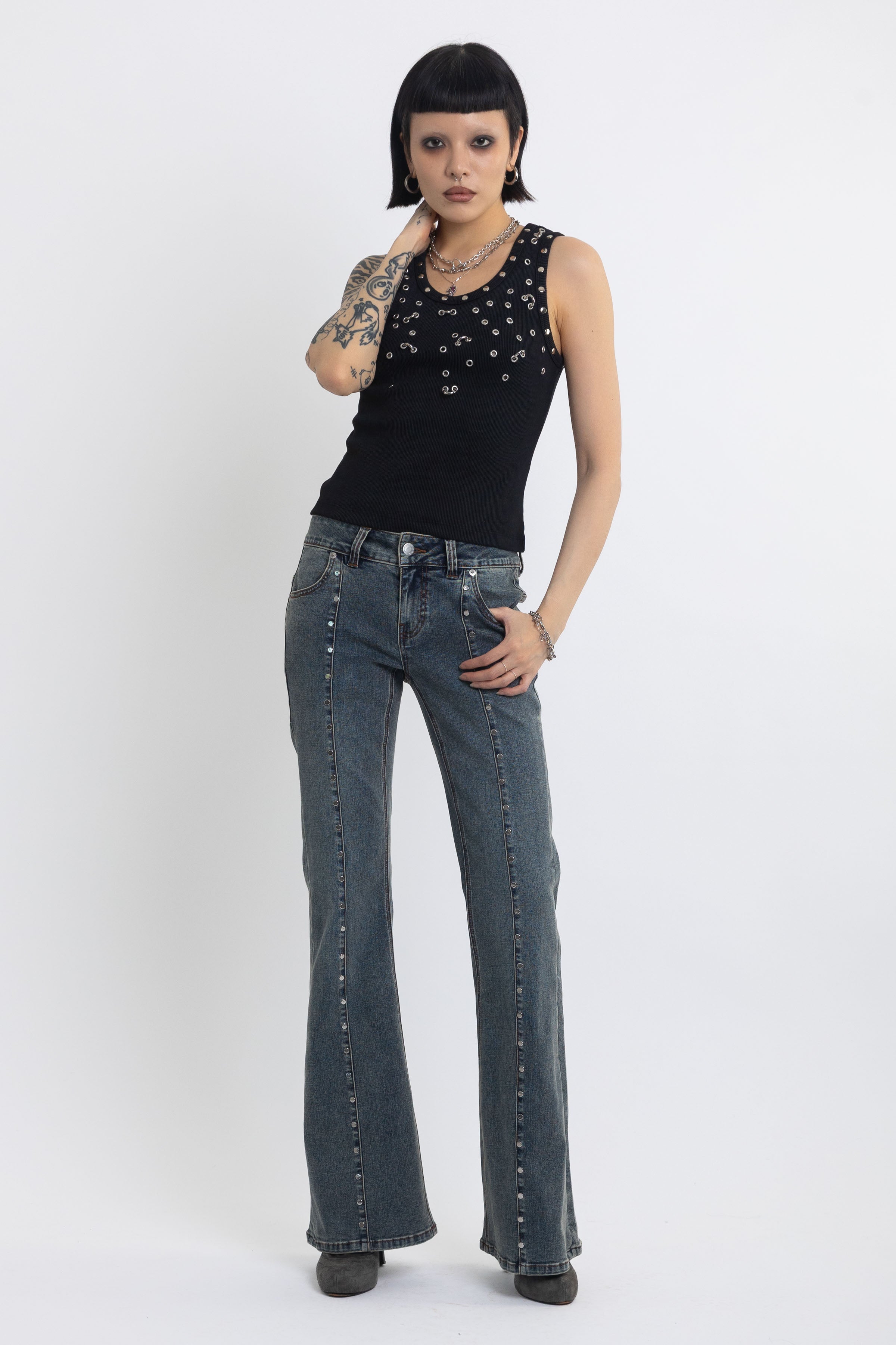 Washed denim low rise flare jeans with silver stud and front seam detail, worn by model
