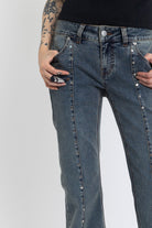 Washed denim low rise flare jeans with silver stud and front seam detail, worn by model