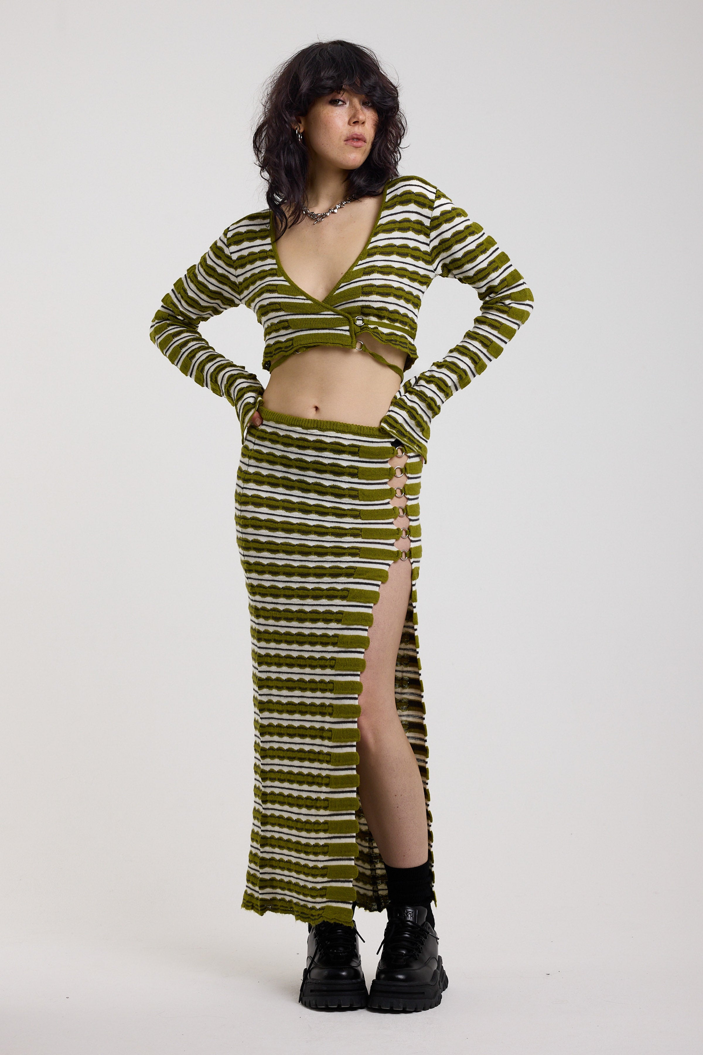 Green textured stripe knit maxi skirt with thigh high split and silver hardware detailing, worn as a co-ord by model