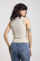 Back image of ecru ribbed tank top with piercing and stud hardware details, worn by a model