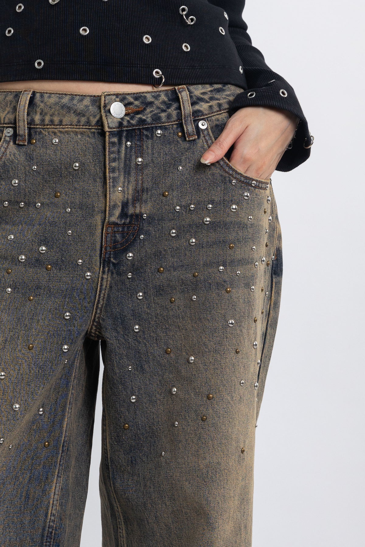 Dirty wash ultra baggy colossus jeans with scattered studs, worn by model