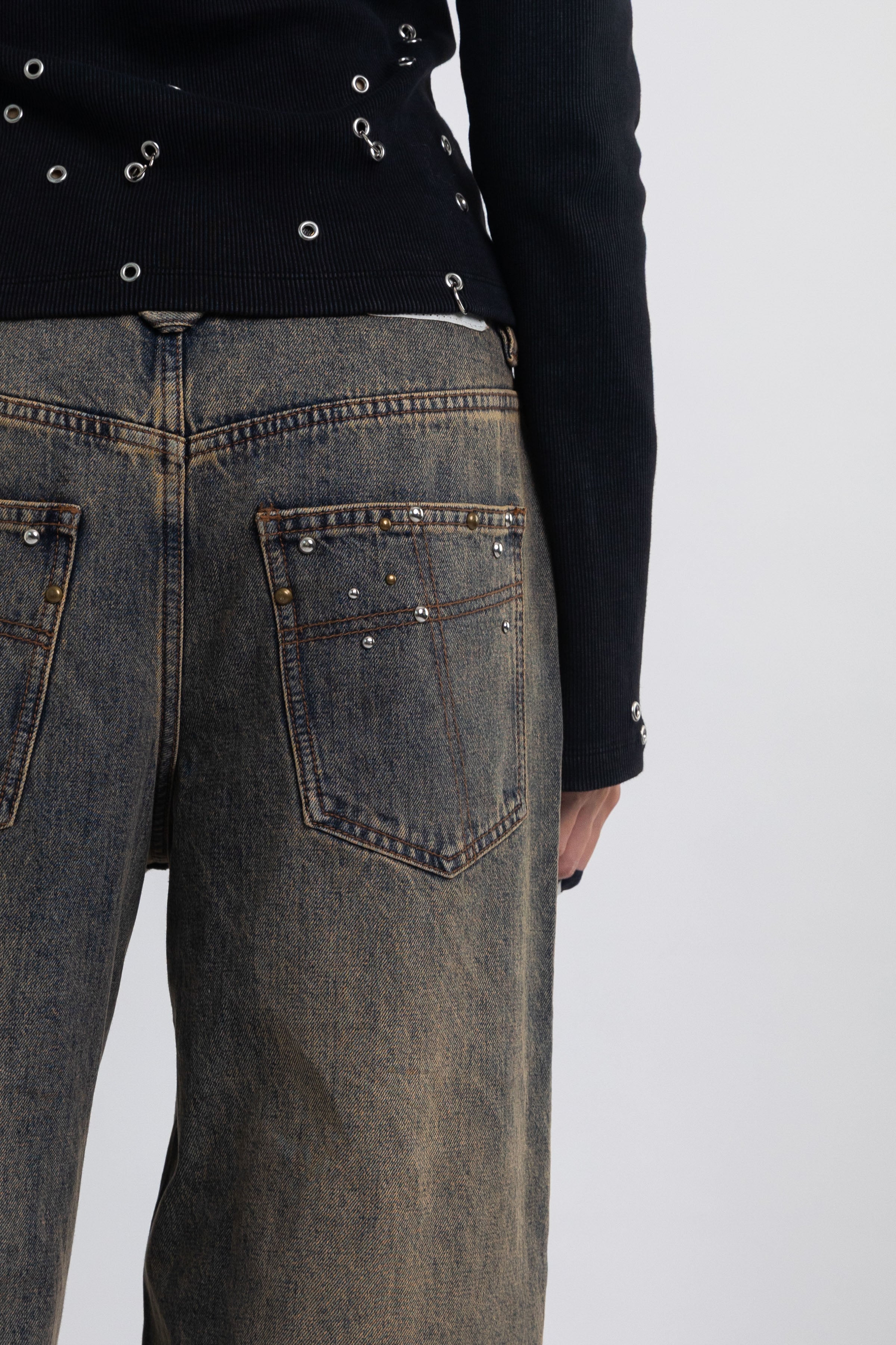 Dirty wash ultra baggy colossus jeans with scattered studs, worn by model