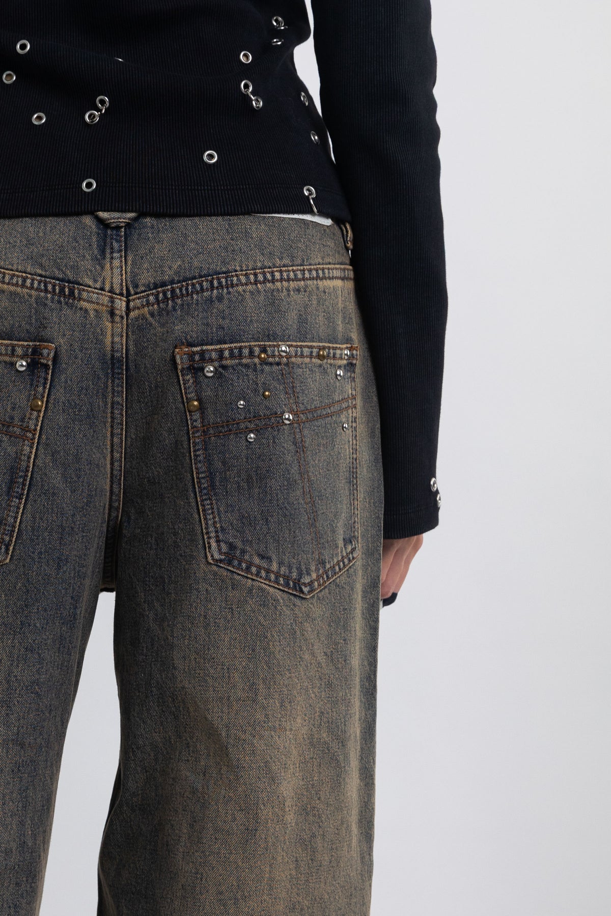 Dirty wash ultra baggy colossus jeans with scattered studs, worn by model