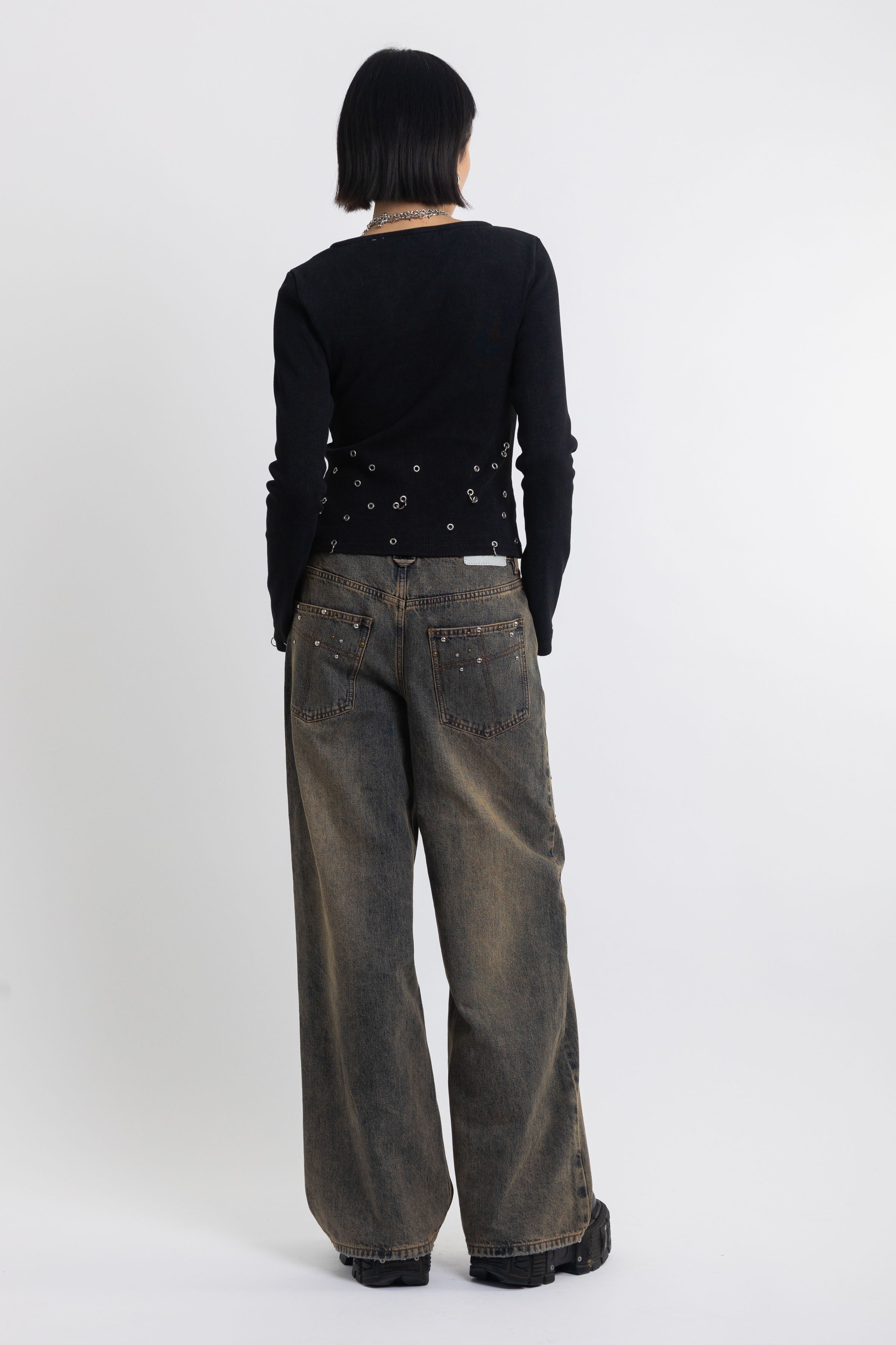 Dirty wash ultra baggy colossus jeans with scattered studs, worn by model