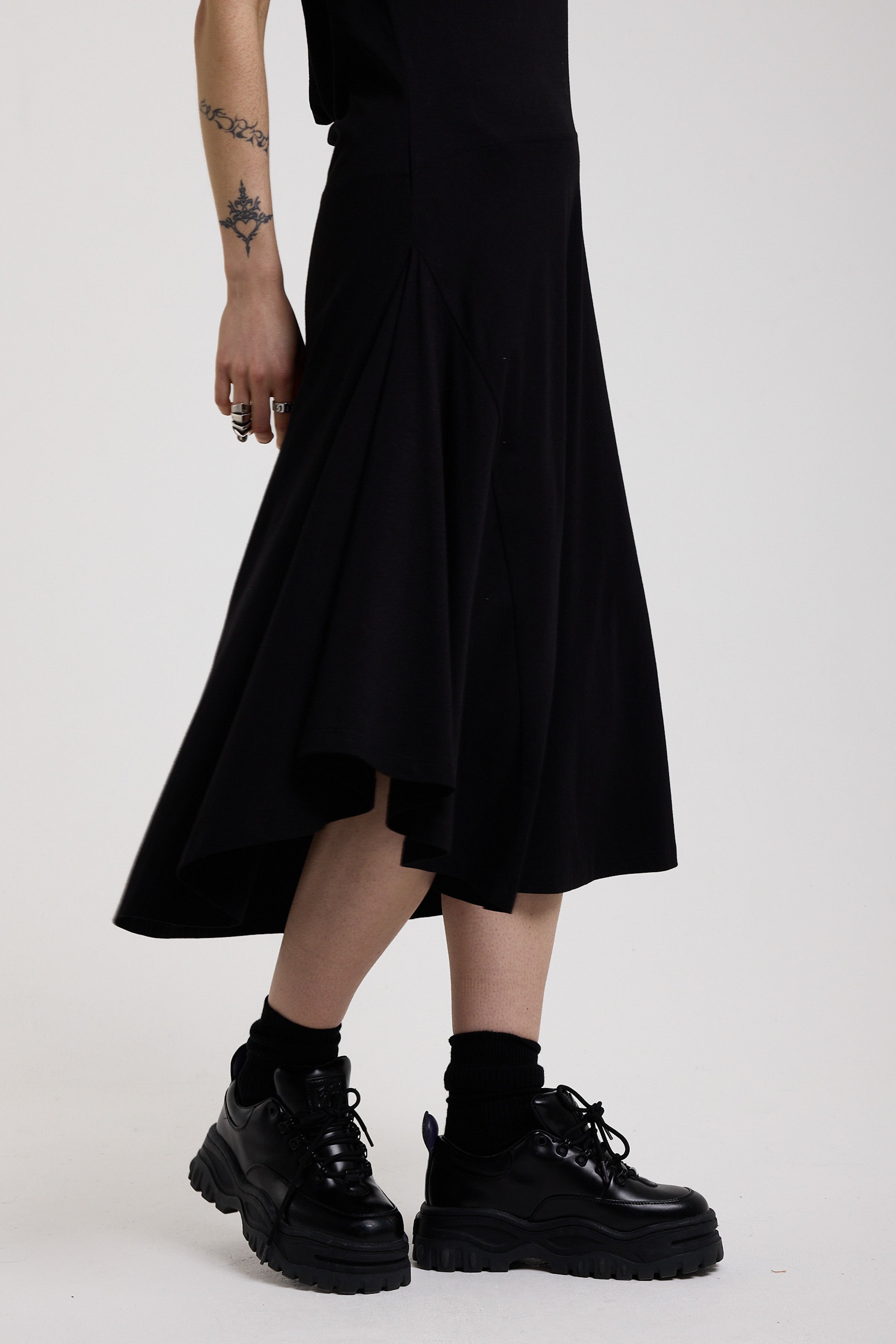 Black slinky midi maxi dress with cowl neck, draped open back, silver O-rings and strappy tie straps, worn by model