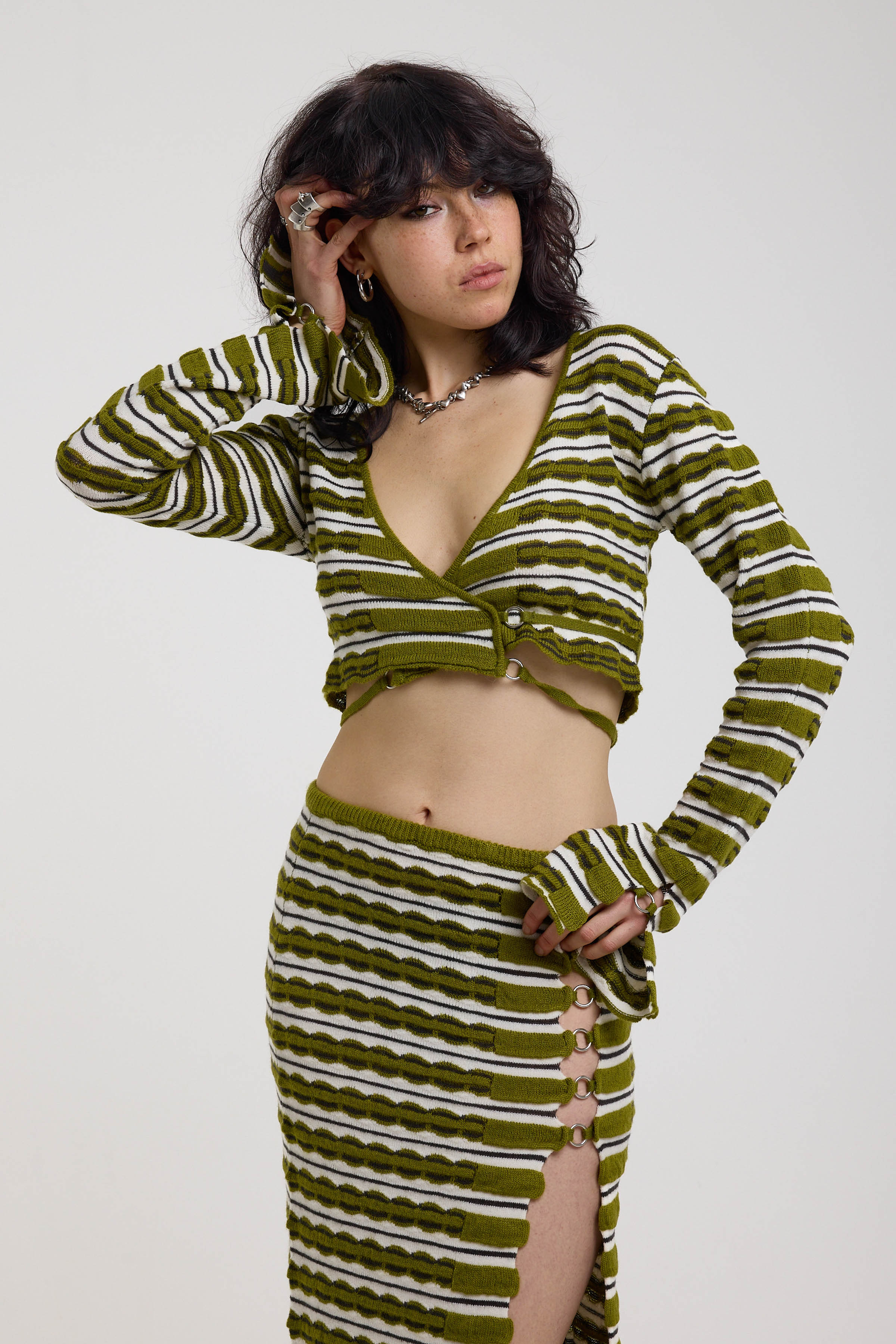 Green textured stripe wrap knit top with plunge neckline and silver hardware detailing, worn by model
