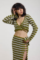 Green textured stripe wrap knit top with plunge neckline and silver hardware detailing, worn by model