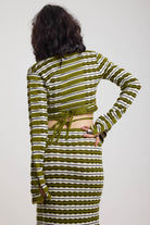 Green textured stripe wrap knit top with plunge neckline and silver hardware detailing, worn by model