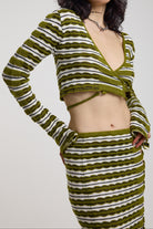 Green textured stripe wrap knit top with plunge neckline and silver hardware detailing, worn by model