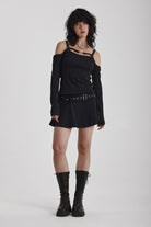 Washed black long-sleeve cold-shoulder mini dress with trigger clasp strap and eyelet belt, worn by model