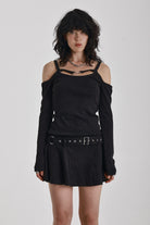 Washed black long-sleeve cold-shoulder mini dress with trigger clasp strap and eyelet belt, worn by model