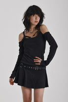 Washed black long-sleeve cold-shoulder mini dress with trigger clasp strap and eyelet belt, worn by model