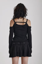 Washed black long-sleeve cold-shoulder mini dress with trigger clasp strap and eyelet belt, worn by model