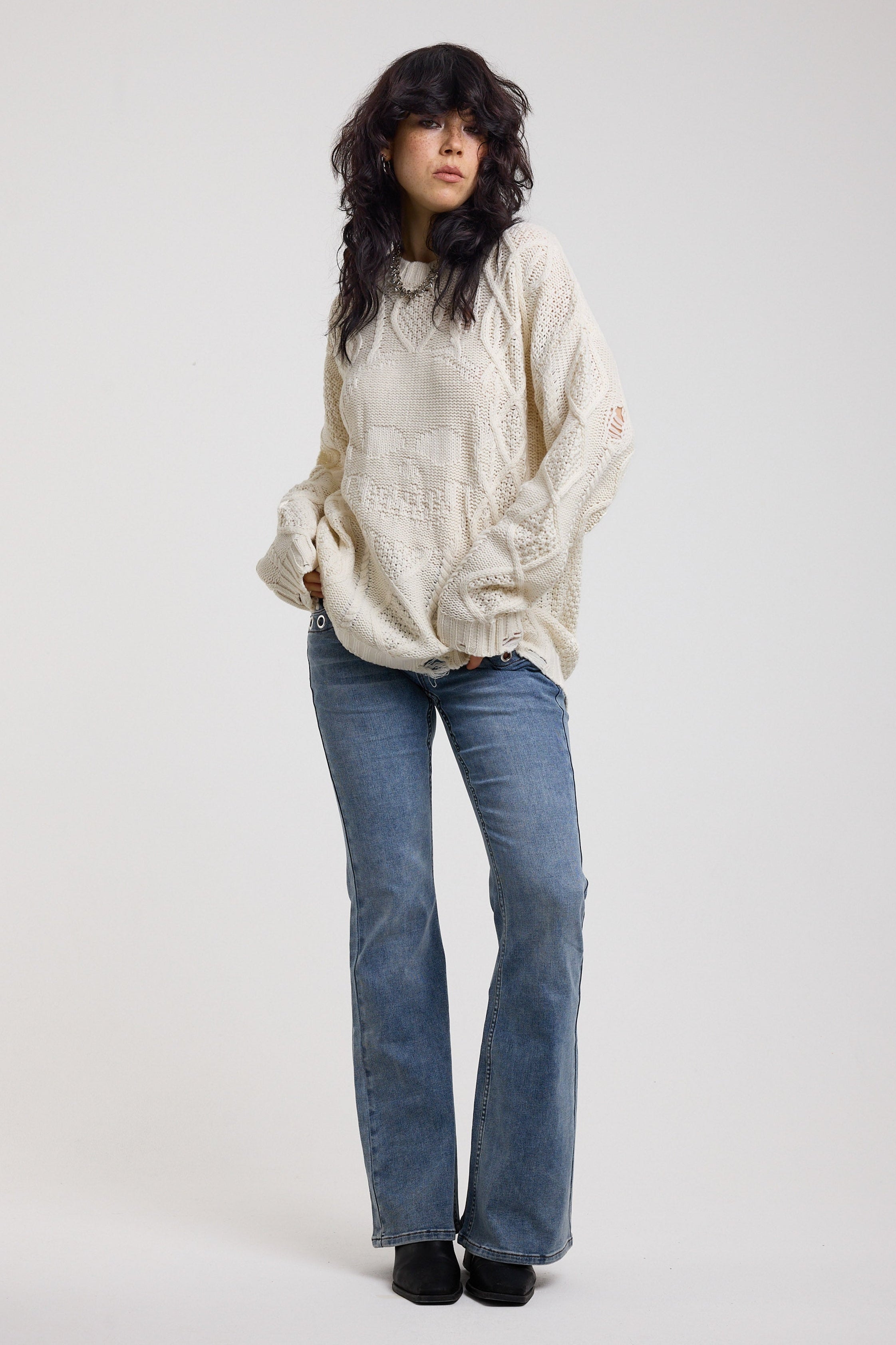 Cream oversized cable knit jumper with skull motif and distressed details, worn by model
