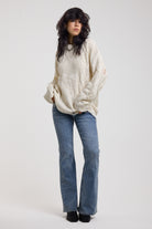 Cream oversized cable knit jumper with skull motif and distressed details, worn by model