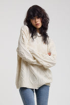 Cream oversized cable knit jumper with skull motif and distressed details, worn by model