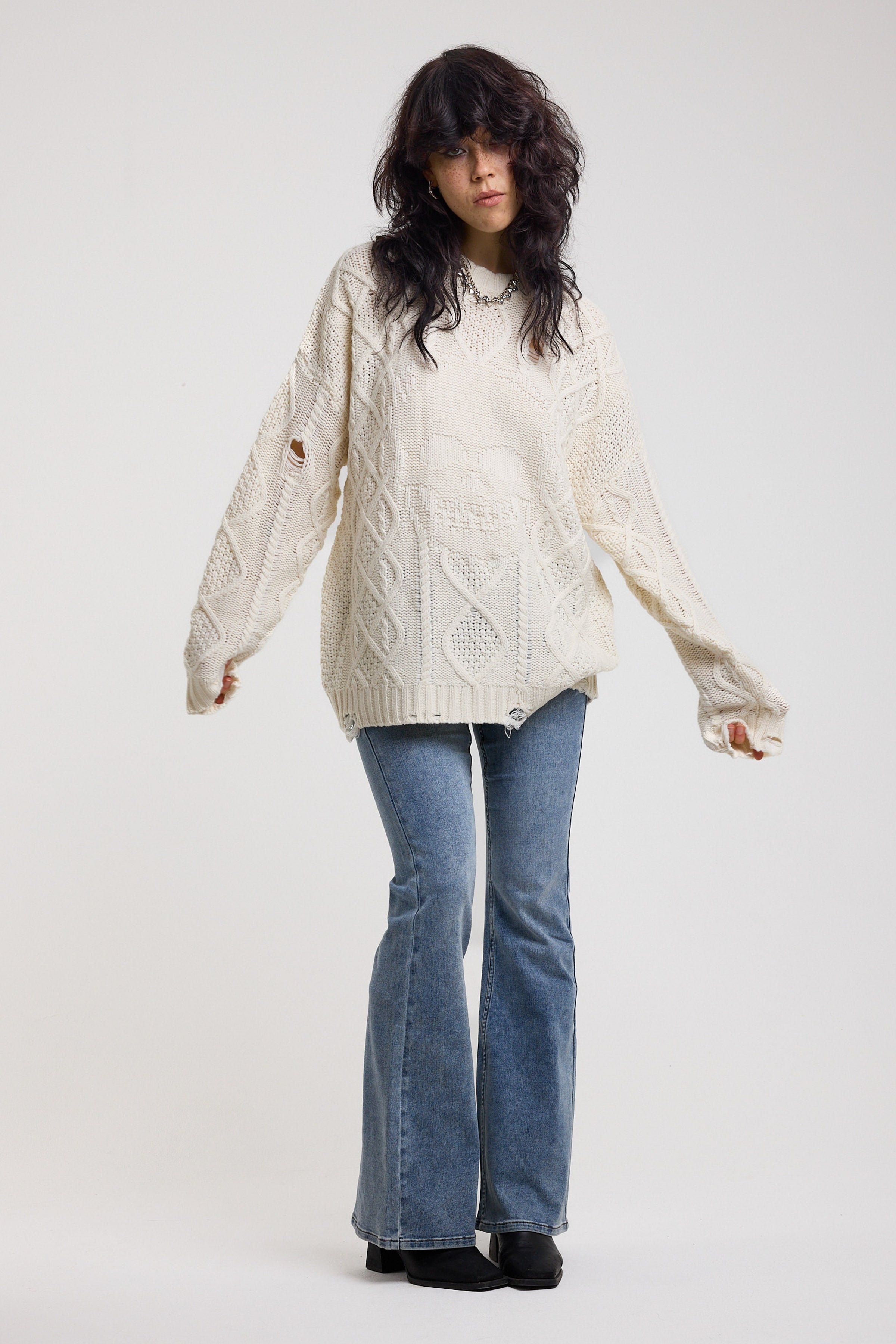 Cream oversized cable knit jumper with skull motif and distressed details, worn by model