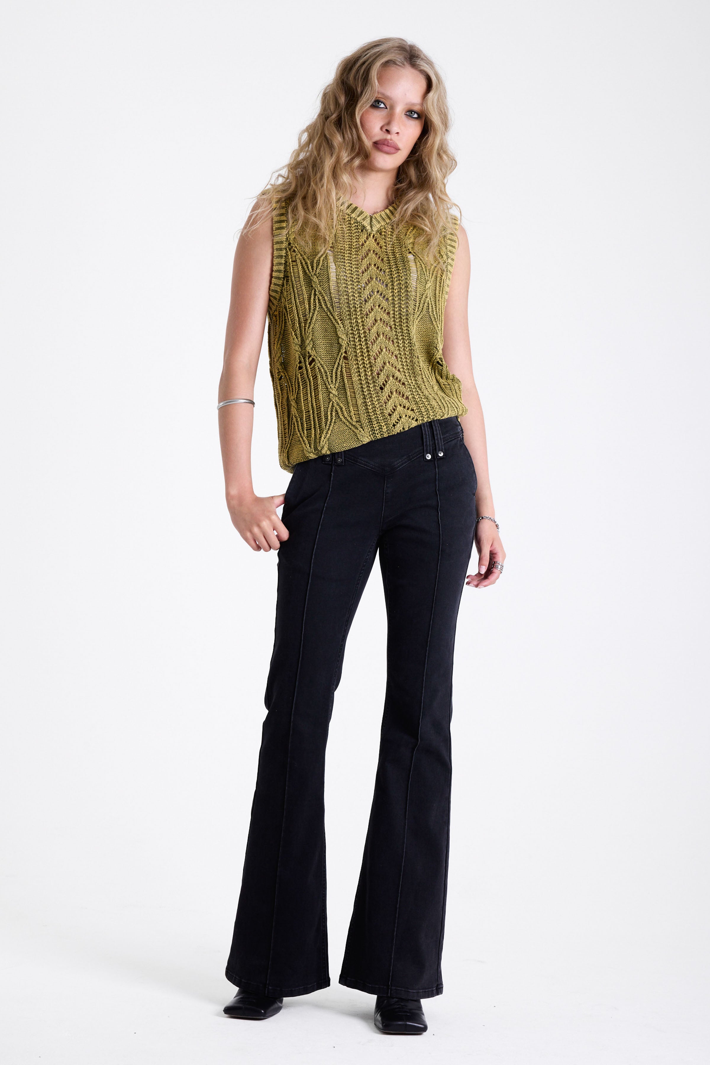 Acid wash green cable knit sweater vest, worn by model.