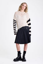 Washed denim pleated midi skirt with double eyelet crossover belt detail, worn by model