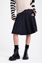 Washed denim pleated midi skirt with double eyelet crossover belt detail, worn by model
