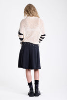 Washed denim pleated midi skirt with double eyelet crossover belt detail, worn by model