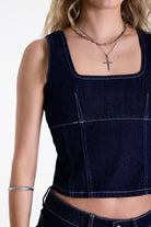 Dark rinse denim square neck corset top with contrast seam detail, worn by model.