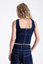 Dark rinse denim square neck corset top with contrast seam detail, worn by model.