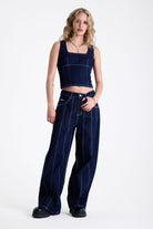 Dark rinse denim square neck corset top with contrast seam detail, worn by model.