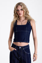 Dark rinse denim square neck corset top with contrast seam detail, worn by model.