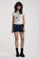 Dark rinse denim hotpants with silver eyelet grommet studs and lace up front detail, worn by model