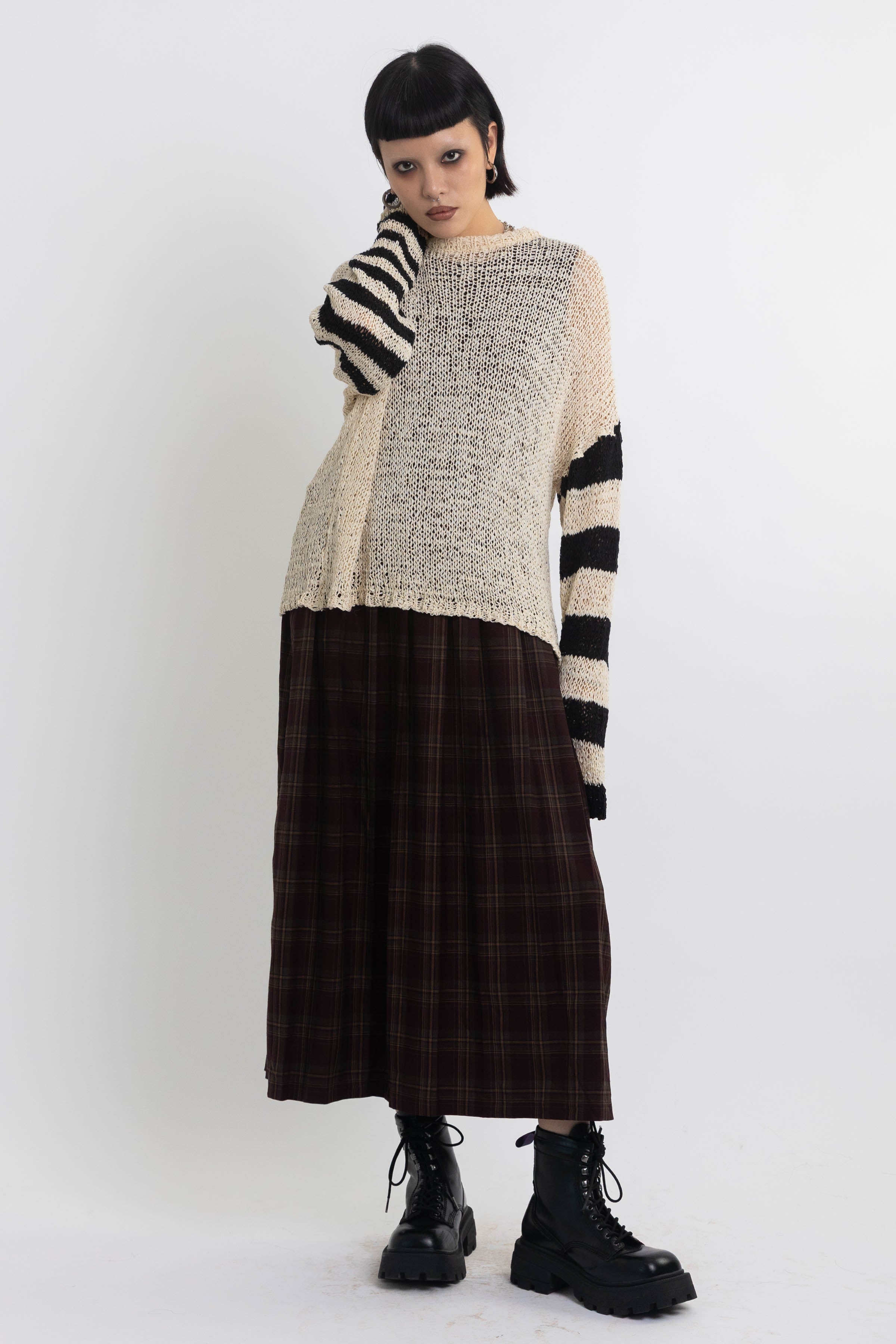 Ecru open knit jumper with asymmetric black stripe sleeves, worn by model
