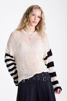 White relaxed open knit jumper with contrasting stripe sleeves, worn by model