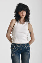 Ecru ribbed tank top with eyelet and buckle strap detail, worn by model
