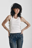 Ecru ribbed tank top with eyelet and buckle strap detail, worn by model