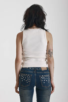 Ecru ribbed tank top with eyelet and buckle strap detail, worn by model