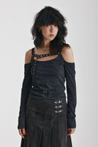 Washed black long-sleeve cold-shoulder top with cutout eyelet straps and silver buckles, worn by model