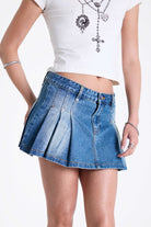 Vintage washed denim mini skirt with box pleats, worn by model.