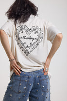 Ecru oversized t-shirt with Ragged logo, featuring a graphic heart motif on the back, worn by model