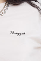 Close up of Ragged vintage logo on ecru oversized t-shirt worn by model