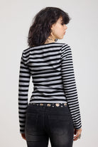 Back image of grey and black stripe asymmetric long sleeve top with stud fastening, worn by a model