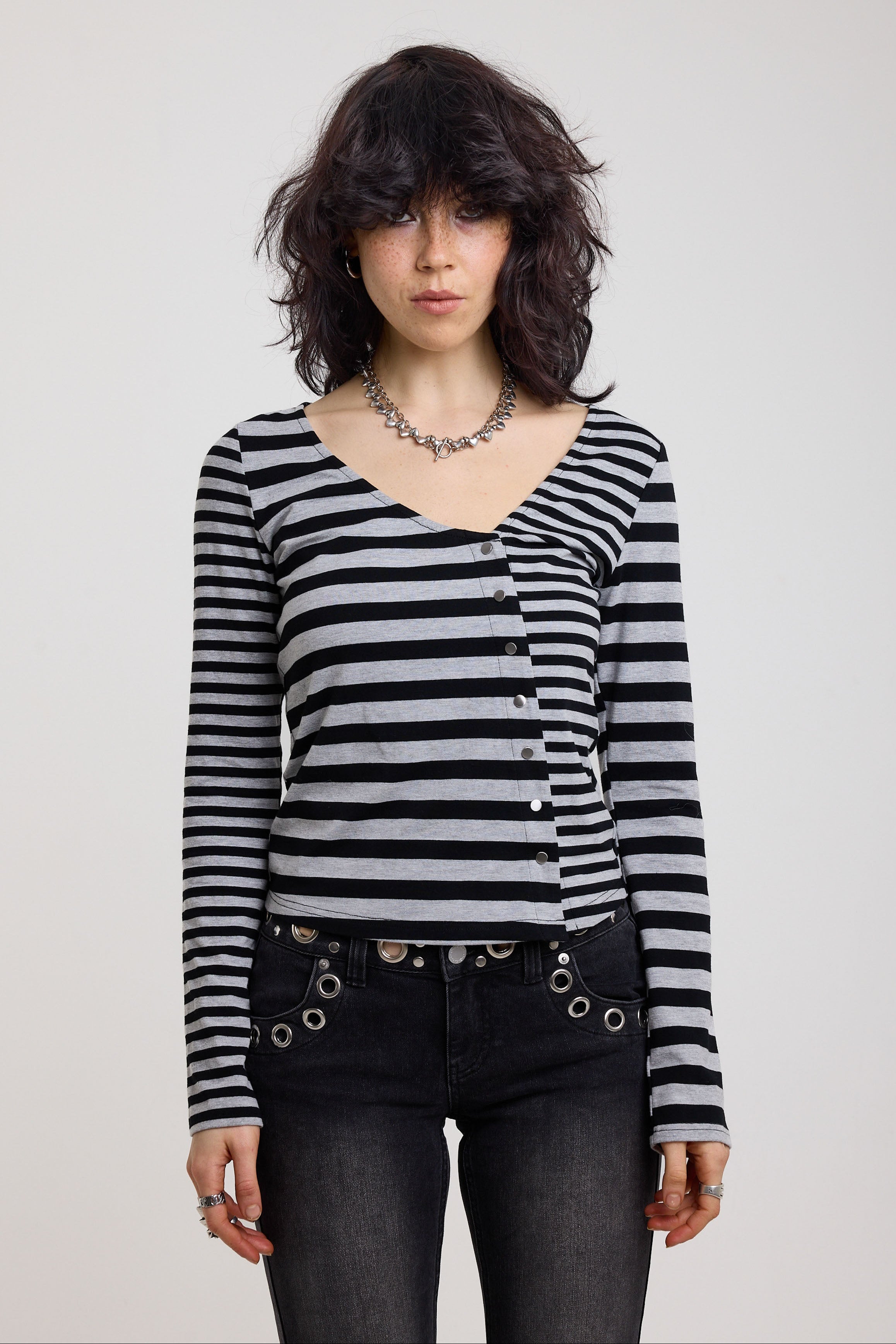 Grey and black stripe asymmetric long sleeve top with stud fastening, worn by a model