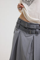 Close up of eyelet detail belt and D rings on grey pinstripe pleated midi skirt