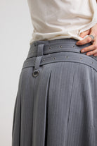 Close up of eyelet detail belt and D rings on grey pinstripe pleated midi skirt