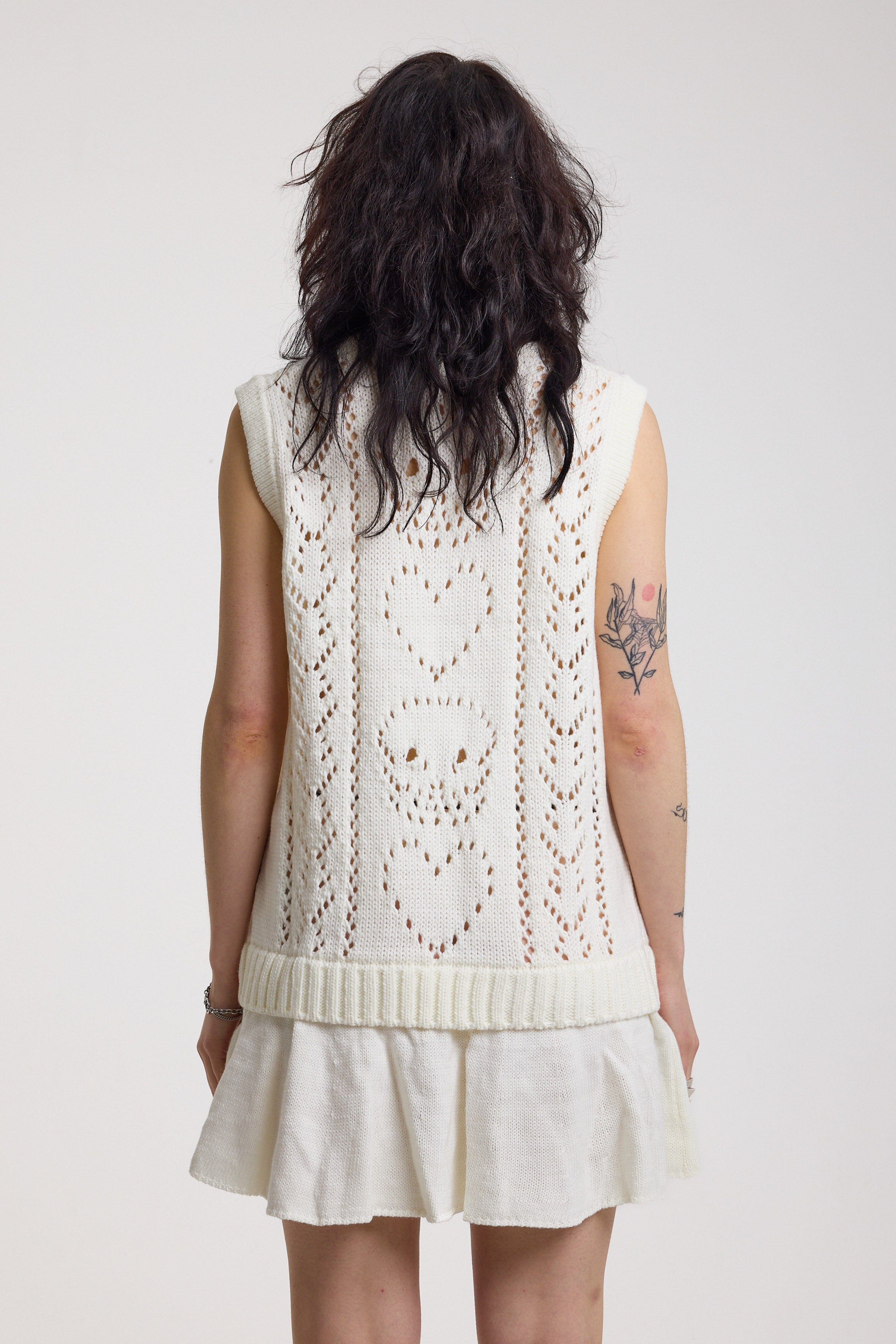 Back of off-white skull and heart pointelle knit mini dress with peplum hem, worn by model