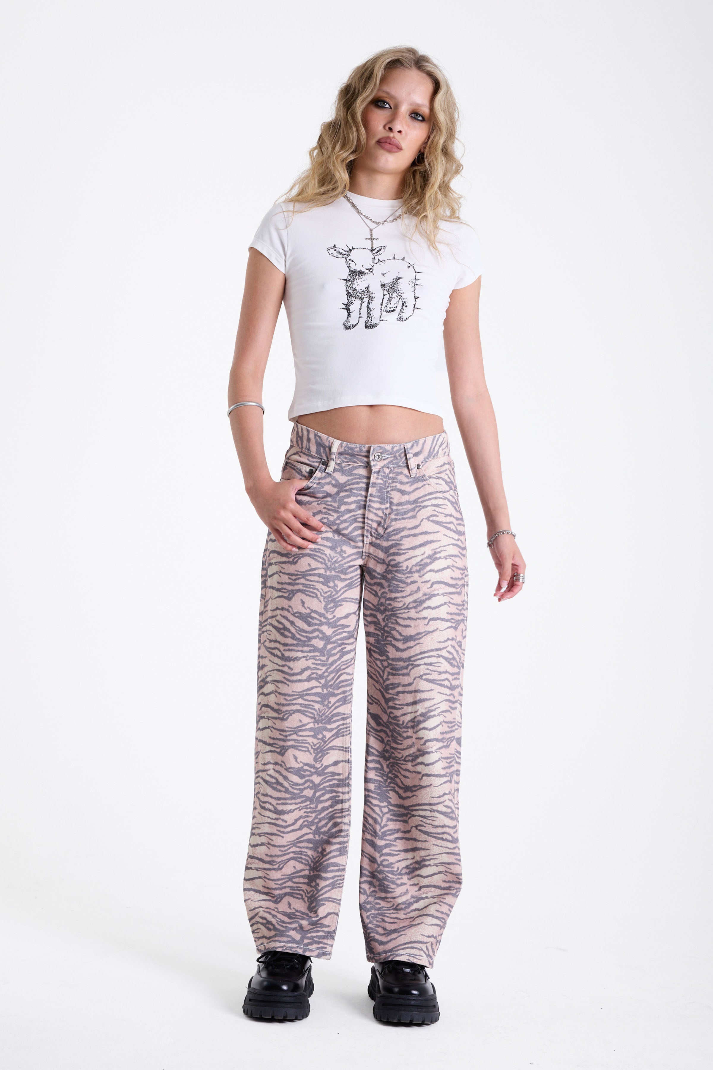 Baggy relaxed leg jeans in all over tiger print, worn by model.