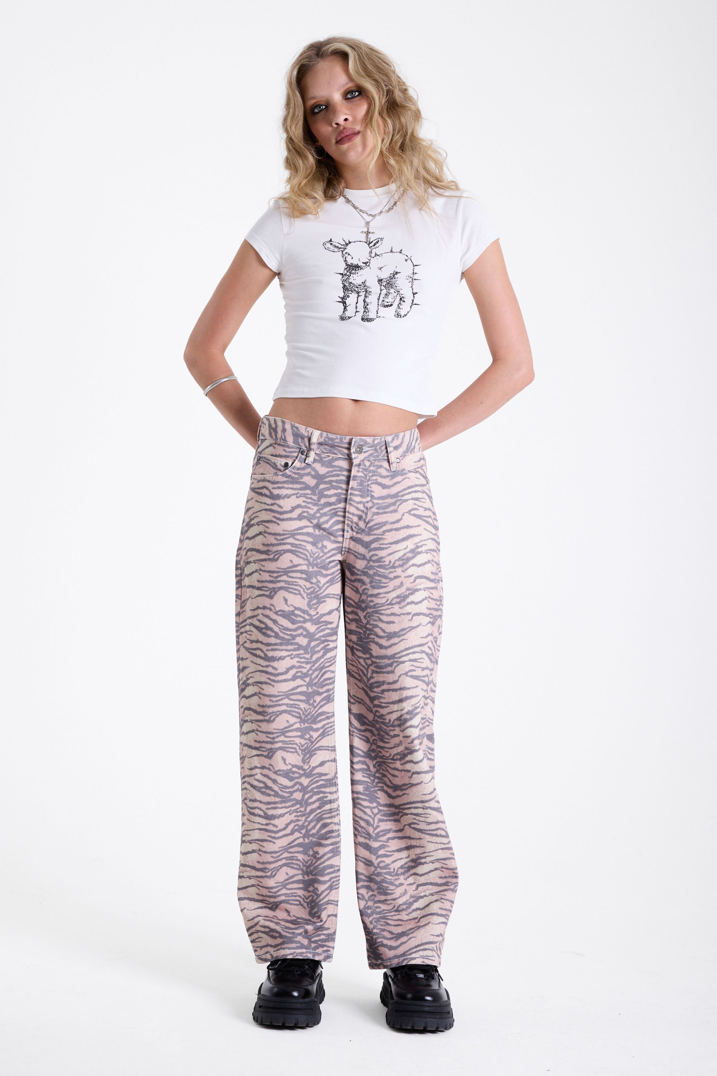 Baggy relaxed leg jeans in all over tiger print, worn by model.