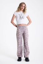 Baggy relaxed leg jeans in all over tiger print, worn by model.