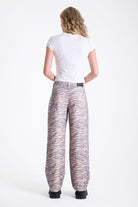 Baggy relaxed leg jeans in all over tiger print, worn by model.