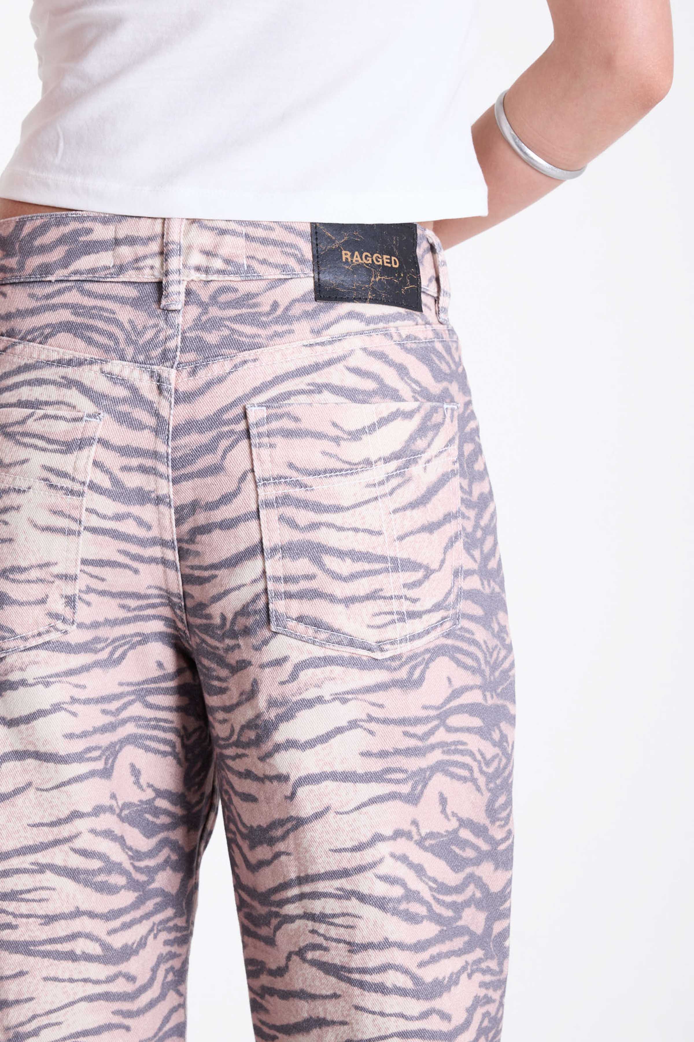 Baggy relaxed leg jeans in all over tiger print, worn by model.