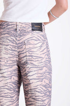 Baggy relaxed leg jeans in all over tiger print, worn by model.